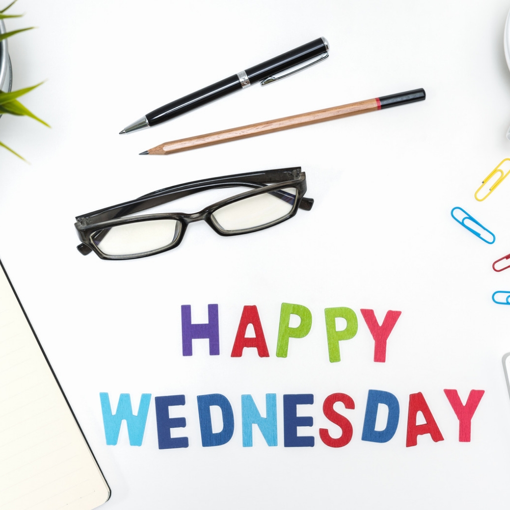 One spectacle, a pencil and a pen on the background with happy wednesday images.